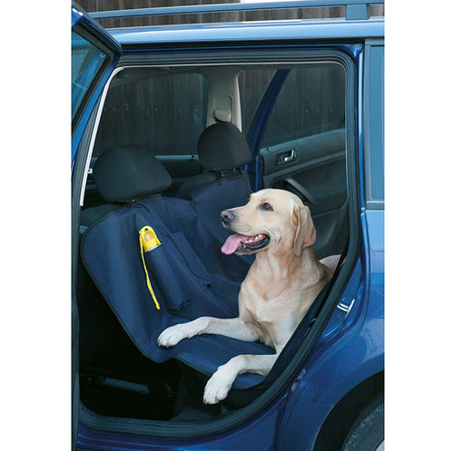 Hund liggandes på bilklädselskydd i bil.